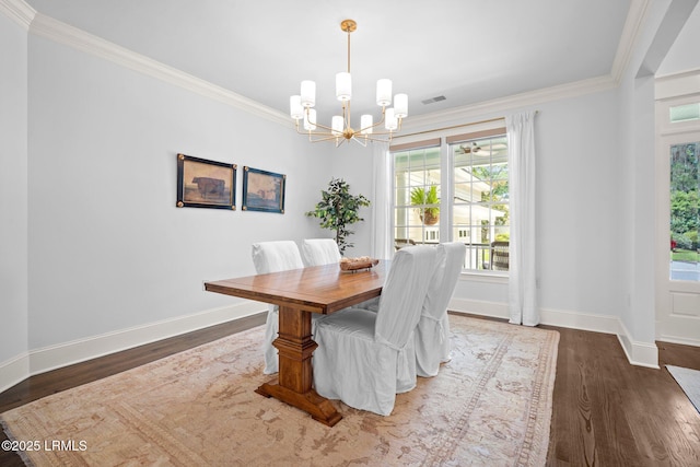 714 Island Cir E, Saint Helena Island, SC 29920 - dining area with a chandelier, crown molding, baseboards, and dark wood-type flooring