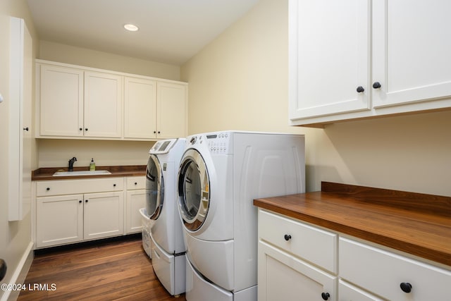 washroom featuring sink, dark wood-type flooring, cabinets, and washer and dryer