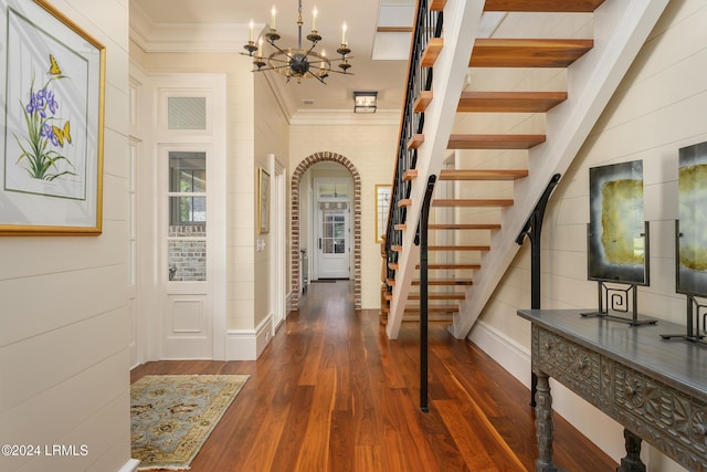 hall featuring dark hardwood / wood-style flooring, ornamental molding, beamed ceiling, and an inviting chandelier