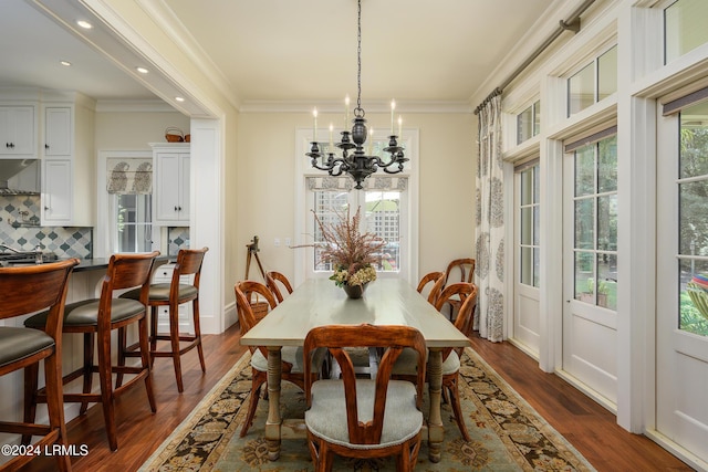 dining space featuring dark hardwood / wood-style flooring, a notable chandelier, and ornamental molding