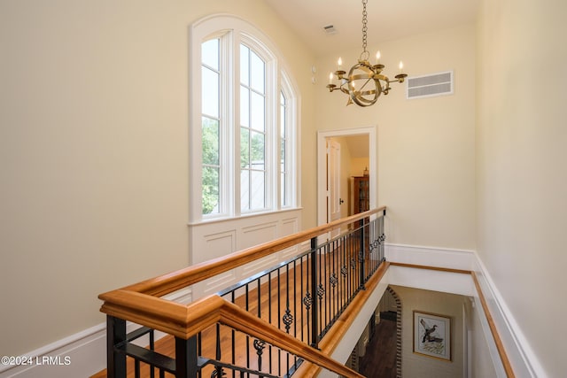 staircase with an inviting chandelier