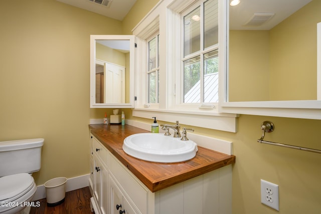 bathroom with hardwood / wood-style flooring, vanity, and toilet