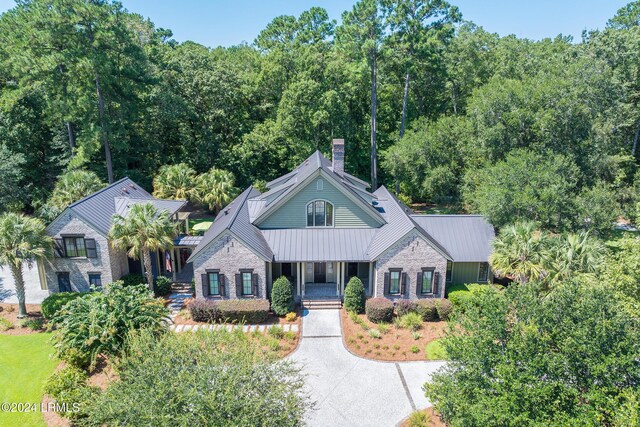 view of front facade with stone siding, metal roof, and a standing seam roof