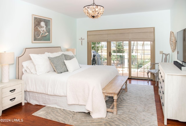 bedroom featuring access to exterior, dark hardwood / wood-style flooring, and a notable chandelier