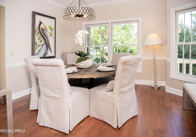 dining area featuring ornamental molding, hardwood / wood-style floors, and an inviting chandelier