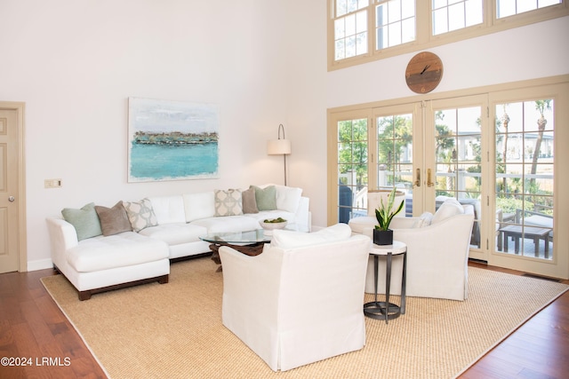 living room featuring a high ceiling, wood-type flooring, and french doors