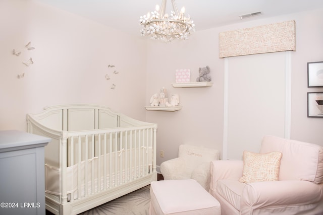 bedroom with a nursery area and a chandelier