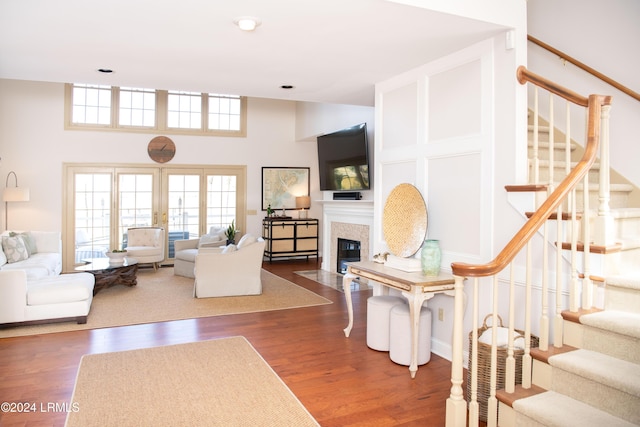 living room featuring dark wood-type flooring and a towering ceiling