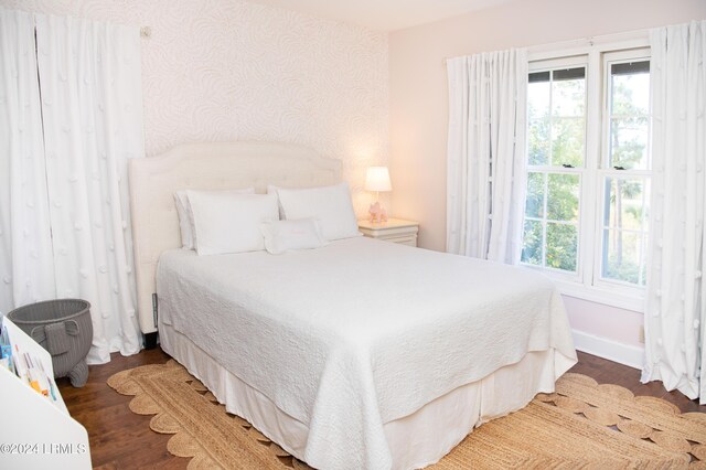 bedroom with dark hardwood / wood-style flooring and multiple windows