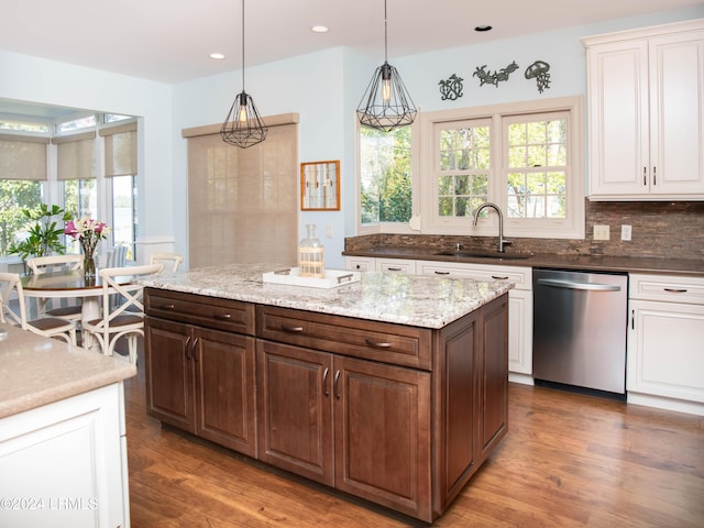 kitchen featuring sink, dark wood-type flooring, tasteful backsplash, decorative light fixtures, and stainless steel dishwasher