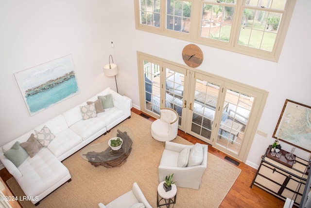 living room featuring hardwood / wood-style floors, plenty of natural light, and a high ceiling