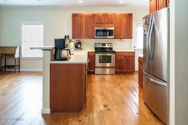 1003 9th St, Port Royal, SC 29935 - kitchen with appliances with stainless steel finishes, brown cabinetry, light wood-style floors, crown molding, and recessed lighting