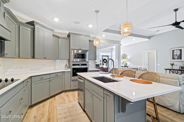 kitchen featuring open floor plan, appliances with stainless steel finishes, and gray cabinetry