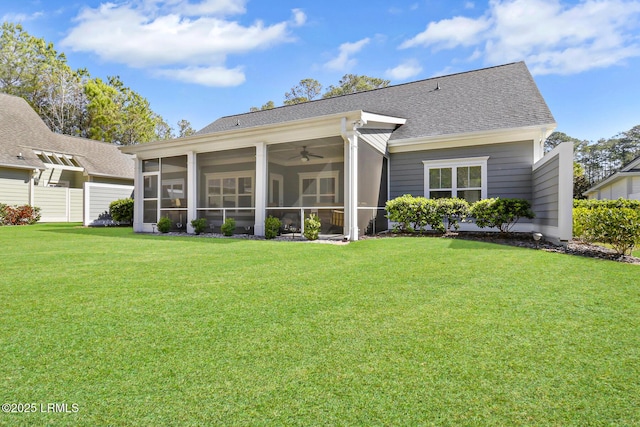 back of property featuring a sunroom, roof with shingles, and a yard