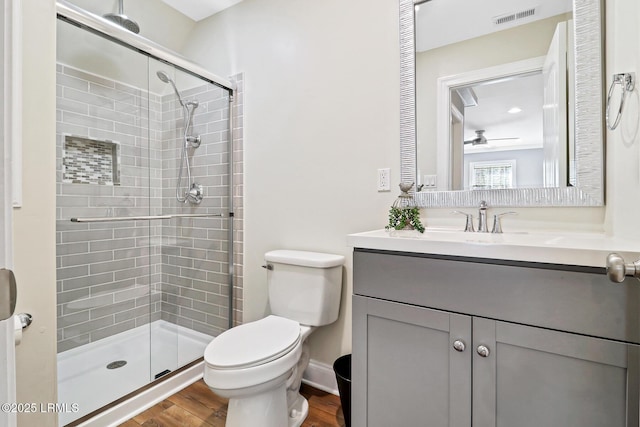 full bath with toilet, a stall shower, vanity, and visible vents