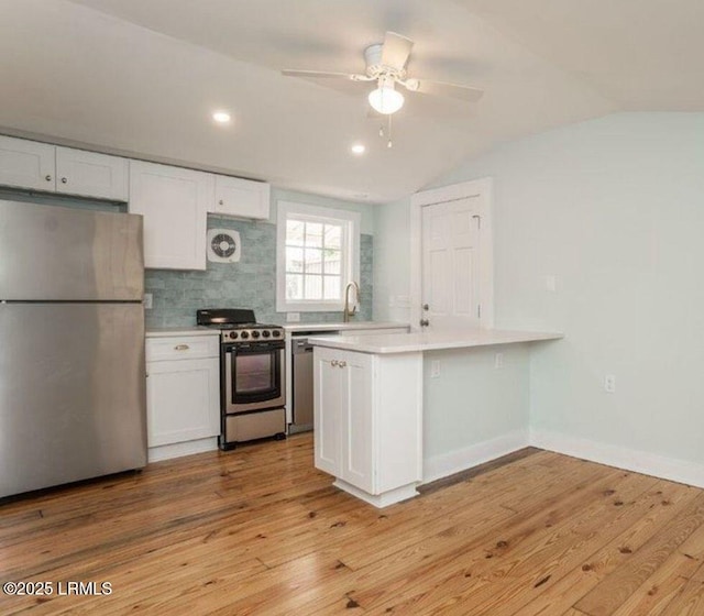 606 Carteret St Cottage, Unit Cottage, Beaufort, SC 29902 - kitchen featuring white cabinets, light countertops, vaulted ceiling, and appliances with stainless steel finishes