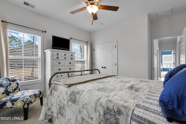 carpeted bedroom with ceiling fan and a closet