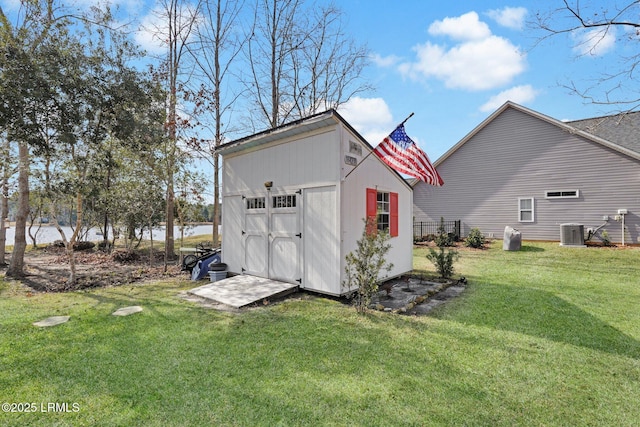 view of outbuilding featuring central AC, a water view, and a yard