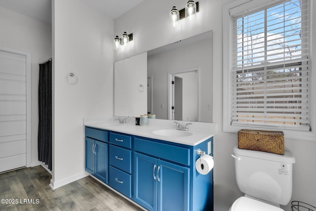 bathroom with wood-type flooring, vanity, and toilet