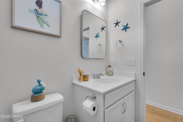 bathroom with vanity, hardwood / wood-style flooring, and toilet