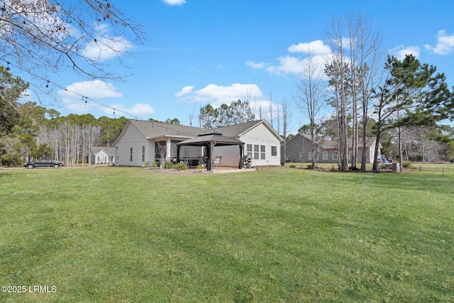 rear view of property with a yard and a gazebo