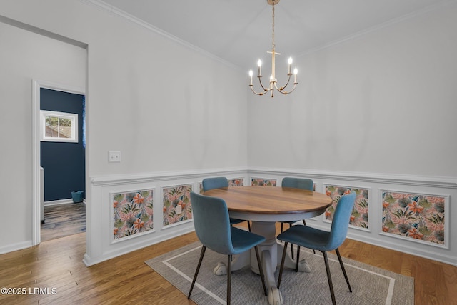 dining space featuring a notable chandelier, crown molding, and wood-type flooring