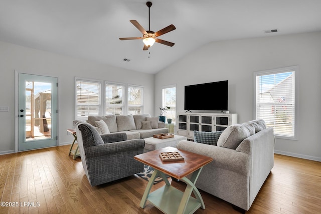 living room featuring ceiling fan, a healthy amount of sunlight, wood-type flooring, and lofted ceiling