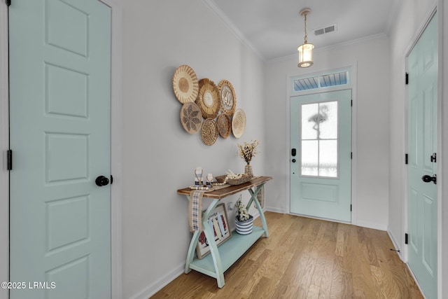 entrance foyer featuring ornamental molding and light hardwood / wood-style flooring