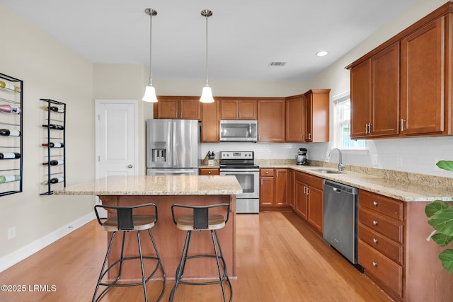 1216 Hearthstone Dr, Ridgeland, SC 29936 - kitchen with brown cabinetry, a sink, light wood-style flooring, and appliances with stainless steel finishes