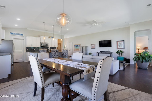 dining area with crown molding, ceiling fan, lofted ceiling, and dark hardwood / wood-style floors