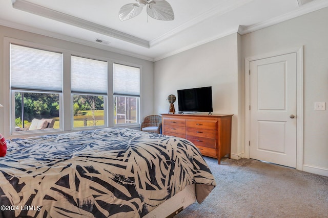 carpeted bedroom with crown molding, ceiling fan, and a tray ceiling