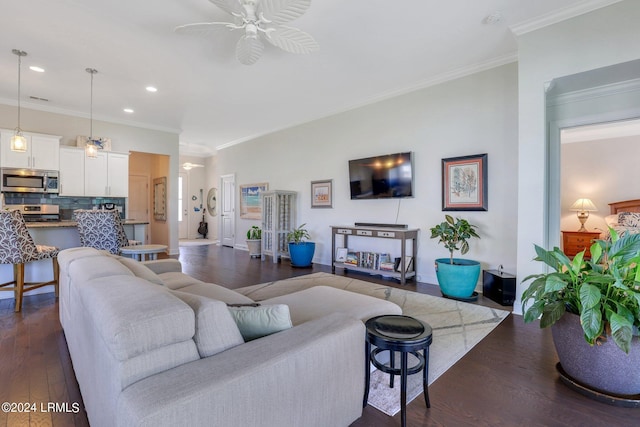 living room featuring ornamental molding, dark wood-type flooring, and ceiling fan