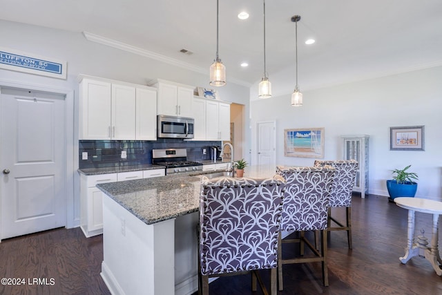 kitchen featuring sink, decorative light fixtures, stainless steel appliances, a kitchen island with sink, and white cabinets