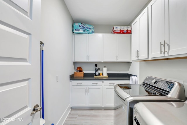 laundry area with cabinet space and separate washer and dryer