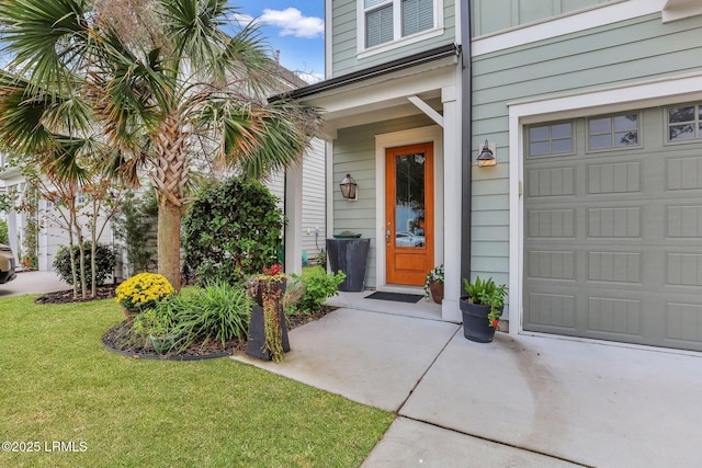 entrance to property featuring a garage and a yard