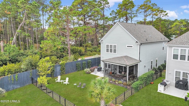 back of property with a patio, a shingled roof, a lawn, a sunroom, and a fenced backyard