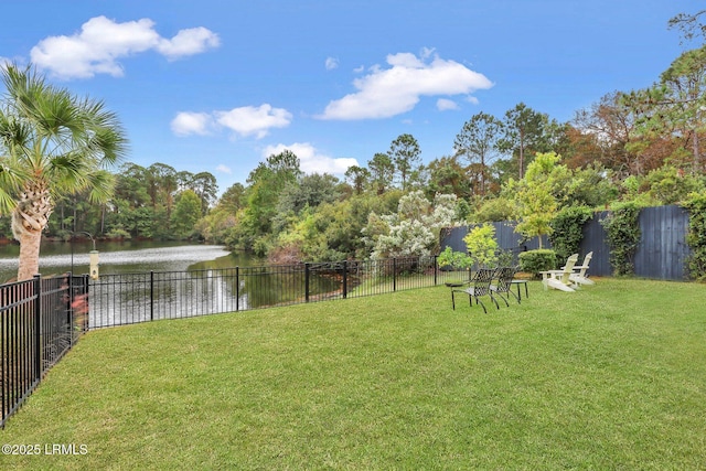 view of yard featuring a water view and fence