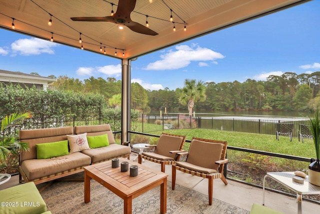 sunroom featuring a ceiling fan, a healthy amount of sunlight, a water view, and track lighting