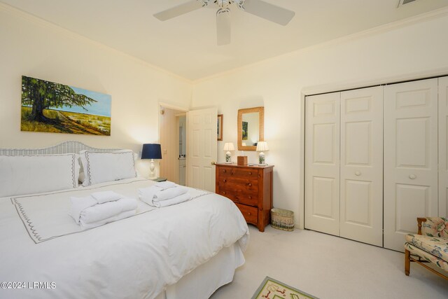 bedroom with light carpet, ornamental molding, a closet, and ceiling fan