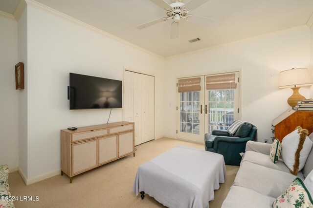 carpeted living room featuring french doors, ceiling fan, and crown molding