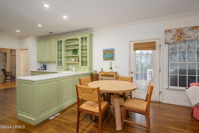 dining area with ornamental molding, dark hardwood / wood-style floors, and sink