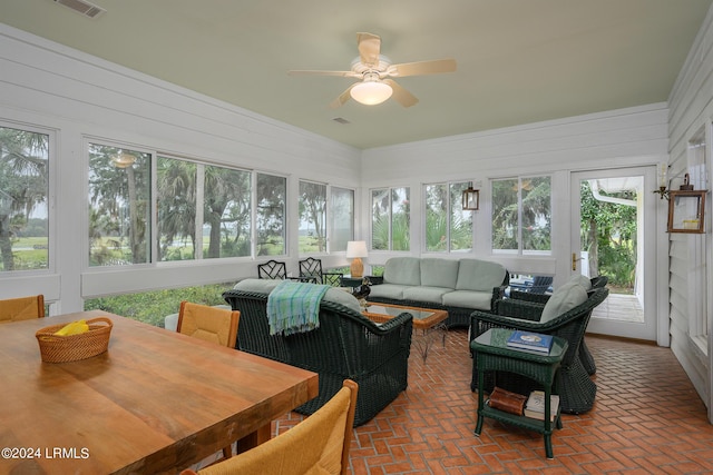 sunroom / solarium with a healthy amount of sunlight and ceiling fan