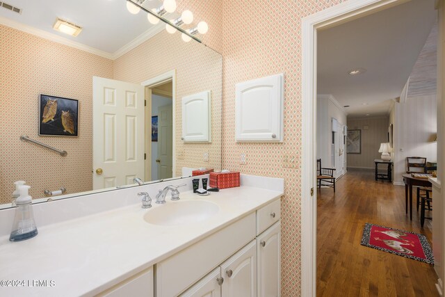 bathroom featuring ornamental molding, wood-type flooring, and vanity