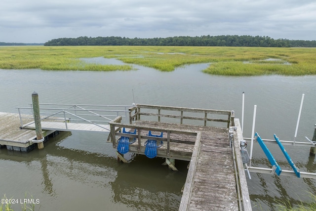 view of dock featuring a rural view and a water view