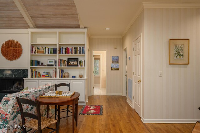 living area featuring ornamental molding, a premium fireplace, and light wood-type flooring