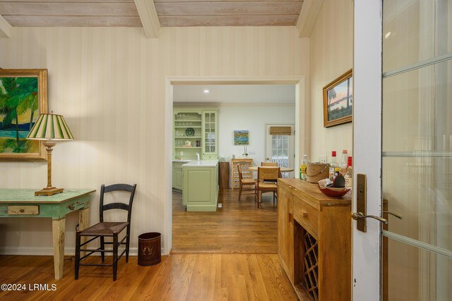 corridor featuring beam ceiling and light hardwood / wood-style flooring