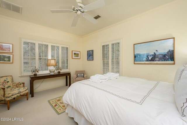 carpeted bedroom featuring ornamental molding and ceiling fan