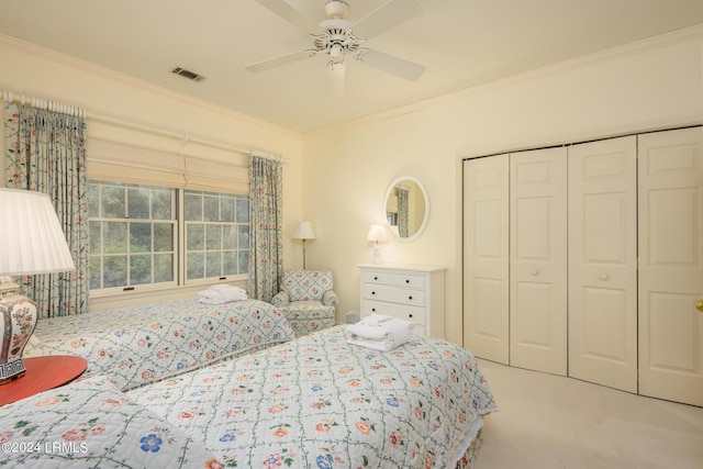 bedroom with crown molding, ceiling fan, carpet, and a closet