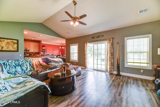 living room with lofted ceiling, ceiling fan with notable chandelier, visible vents, and dark wood-style flooring