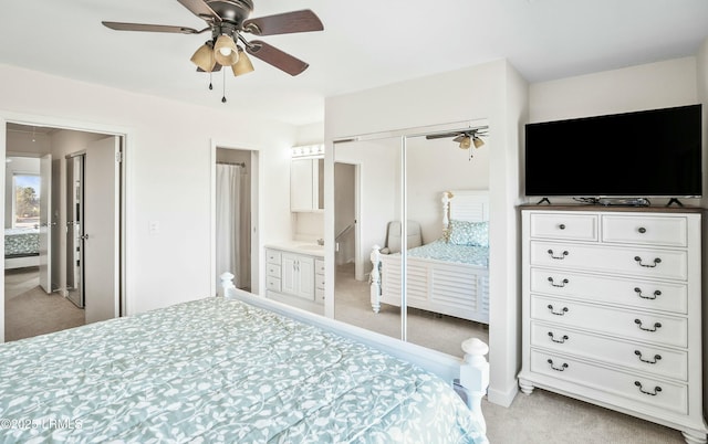 bedroom featuring ceiling fan, light colored carpet, connected bathroom, and a closet